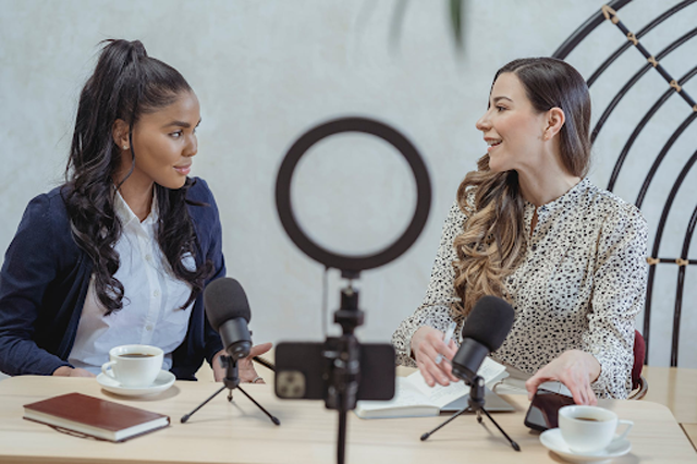 An interview is another type of content that creators do and post on Youtube. Image: Smiling woman interviewing black female guest and recording video by George Milton, licensed under Pexels.